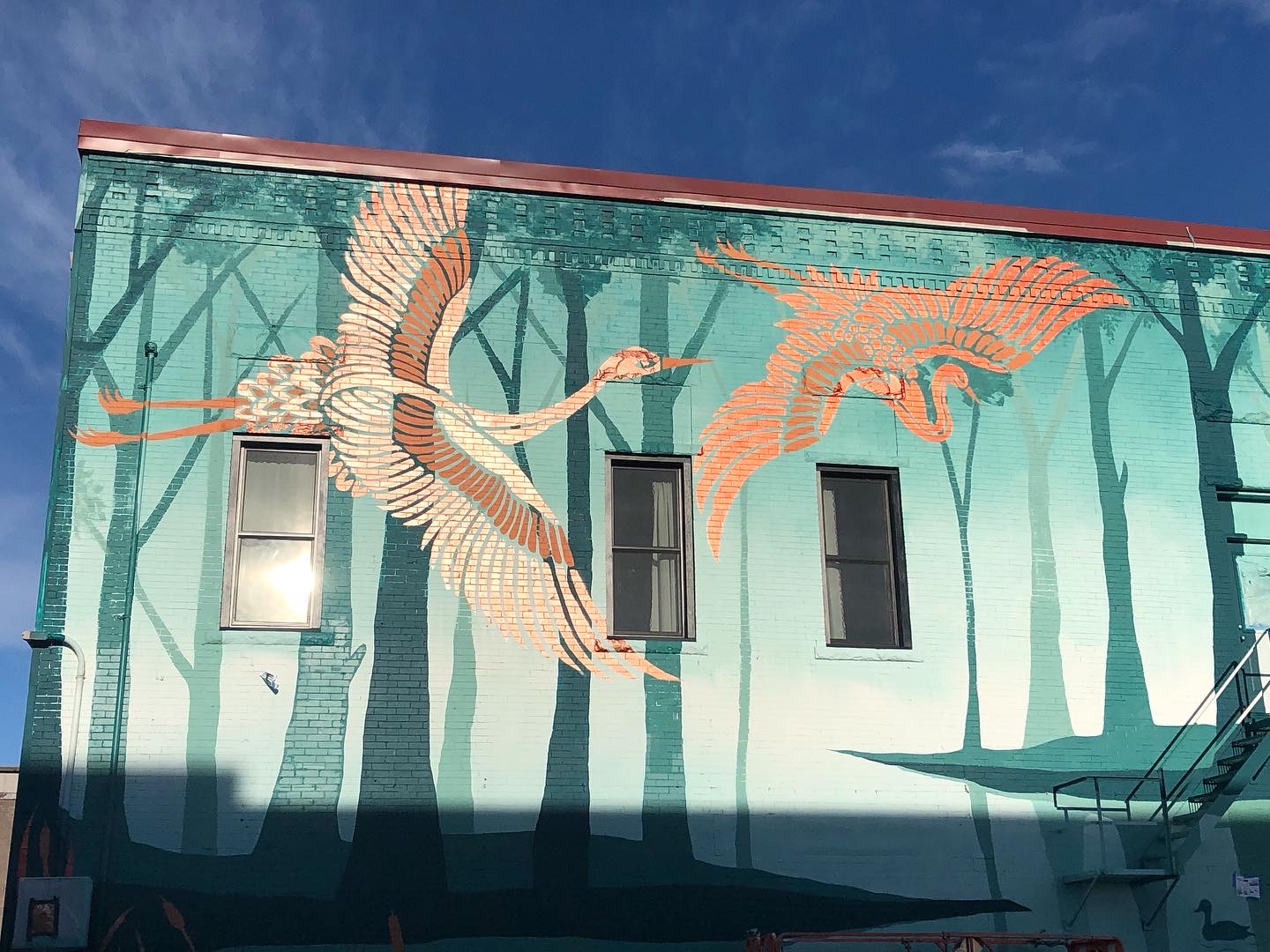Sanctuary mural detail with a sandhill crane and teal foliage.