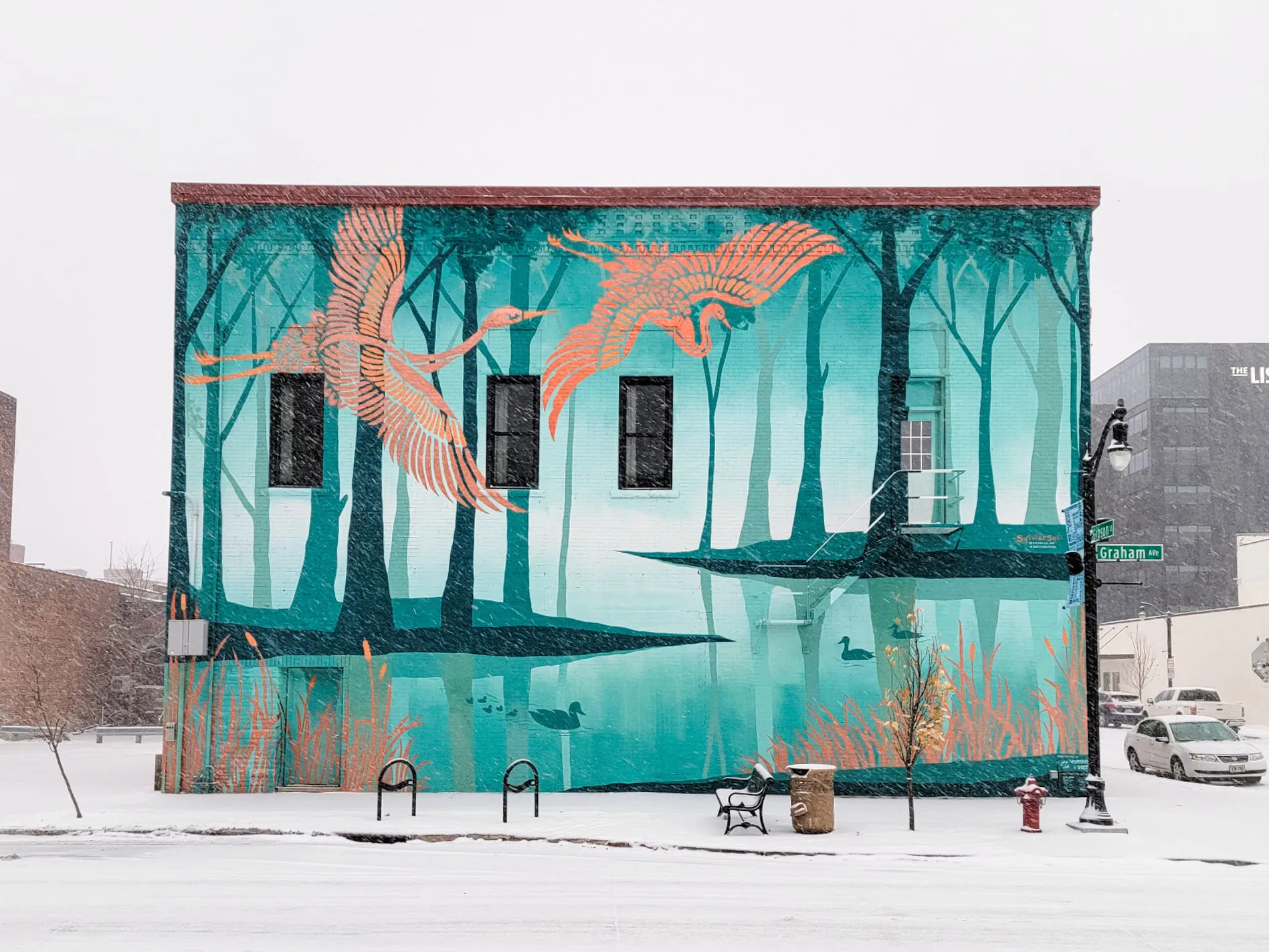 The Sanctuary mural in winter, the downtown building framed by snow.