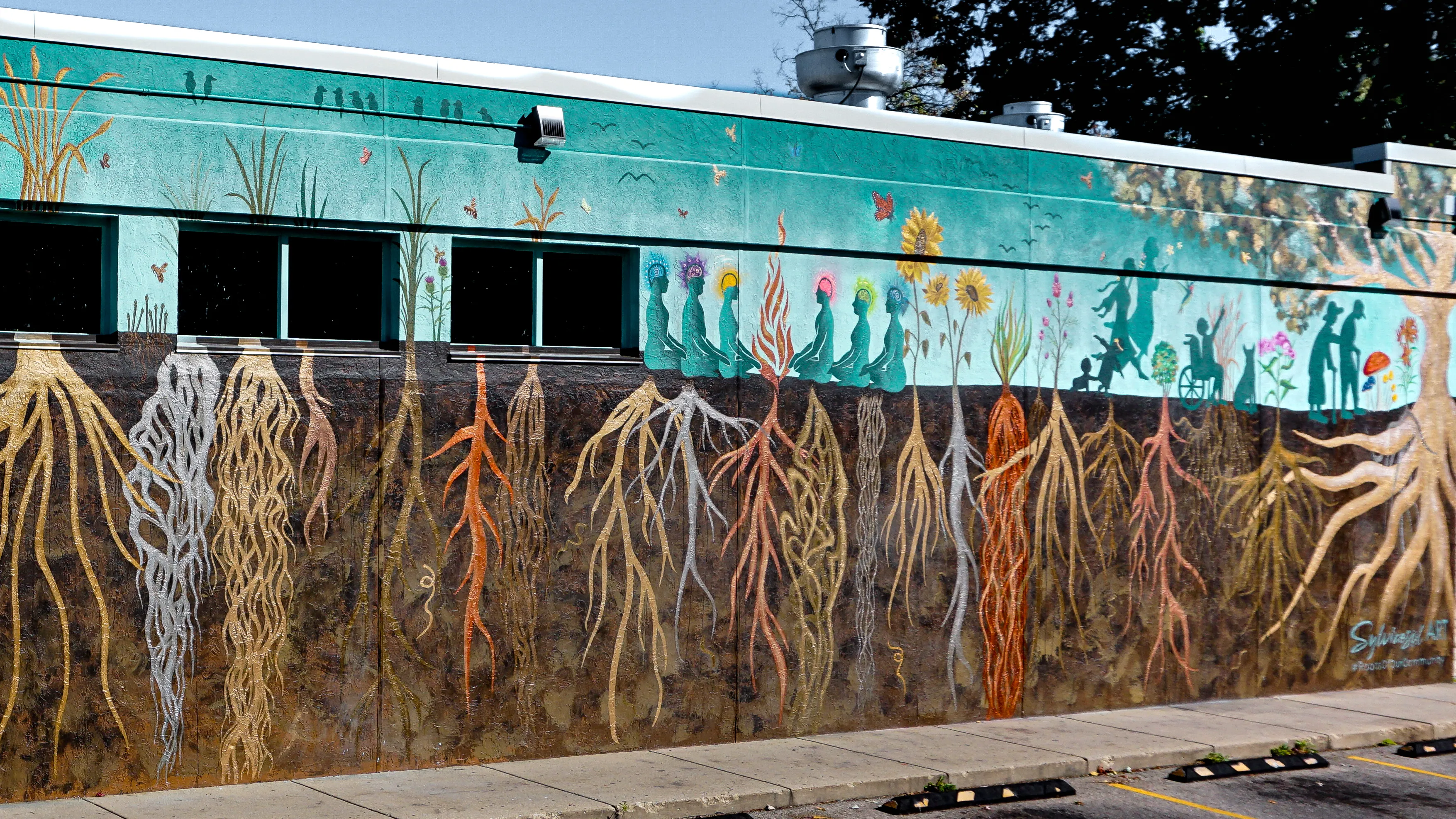 Roots mural with gold-leaf accents and silhouetted figures.