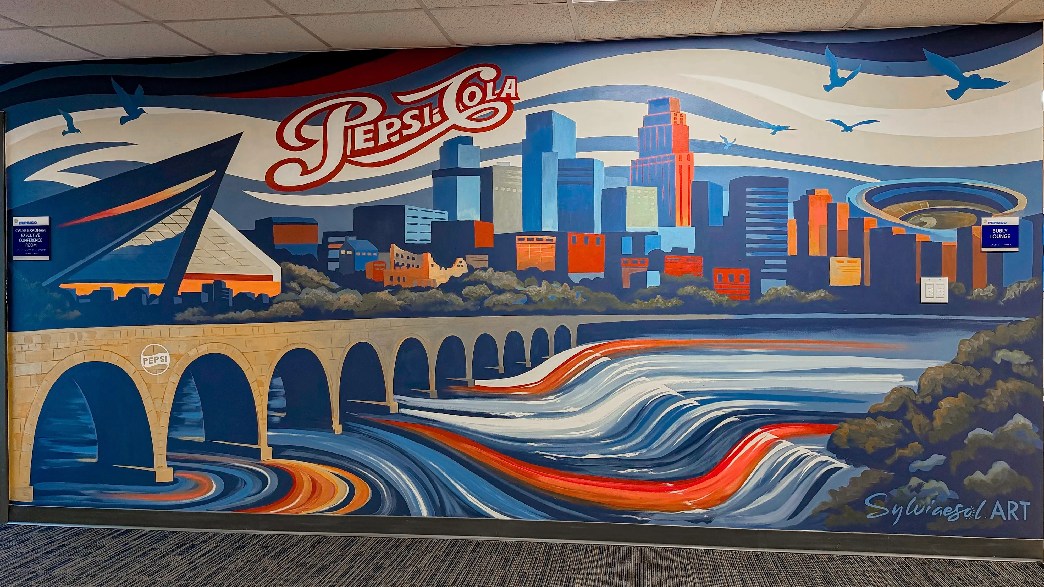 Mural of the Minneapolis skyline and Stone Arch Bridge with retro Pepsi-Cola lettering.