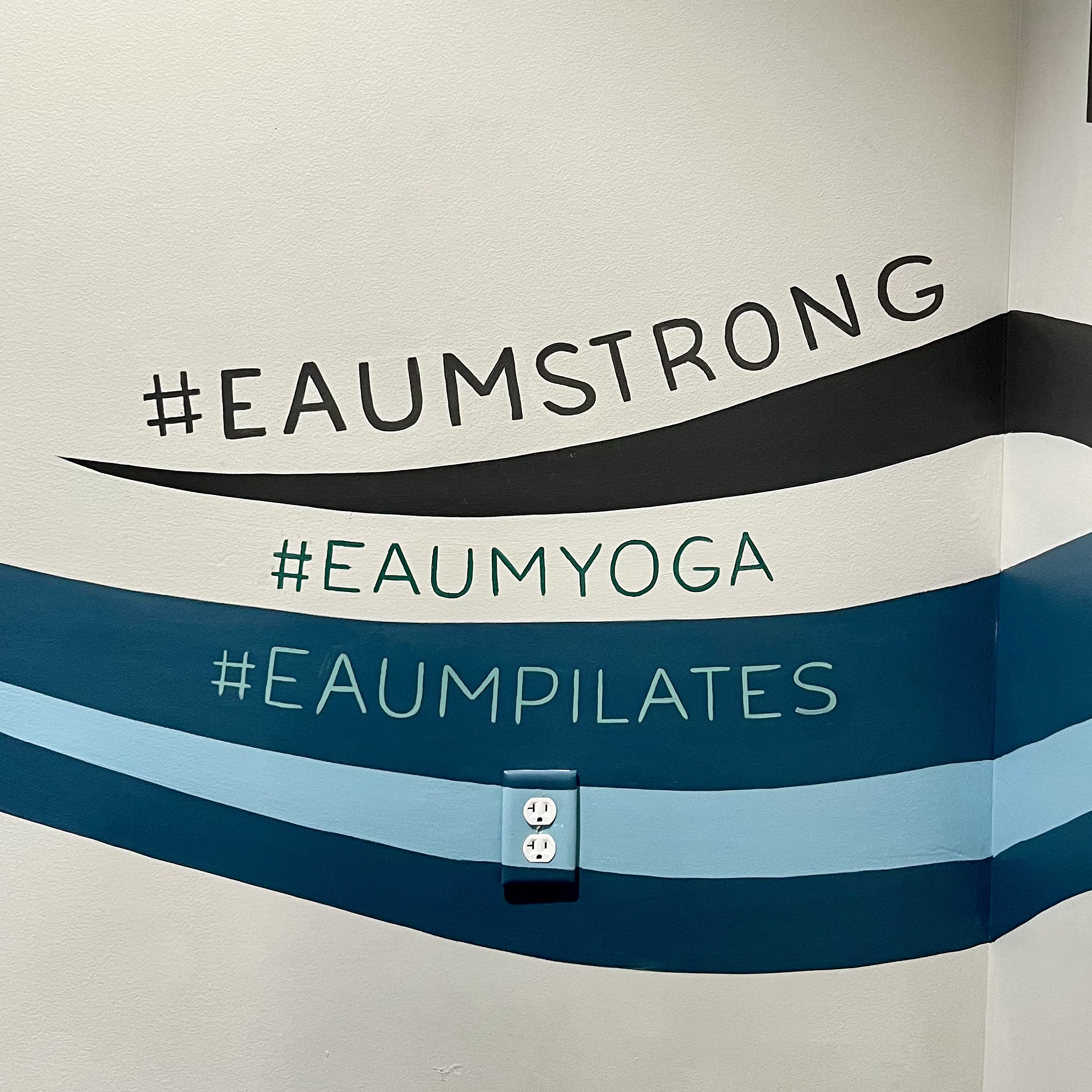 Eaum Yoga interior with mural section visible.