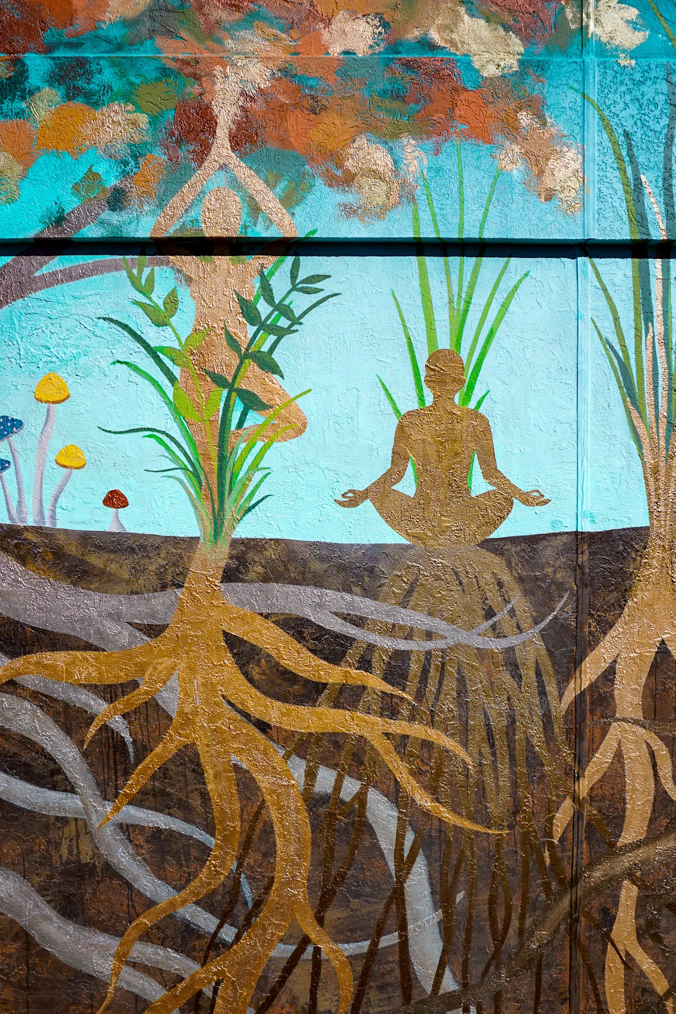 Detail of gold-leaf roots beneath a meditating figure and a teal sky.